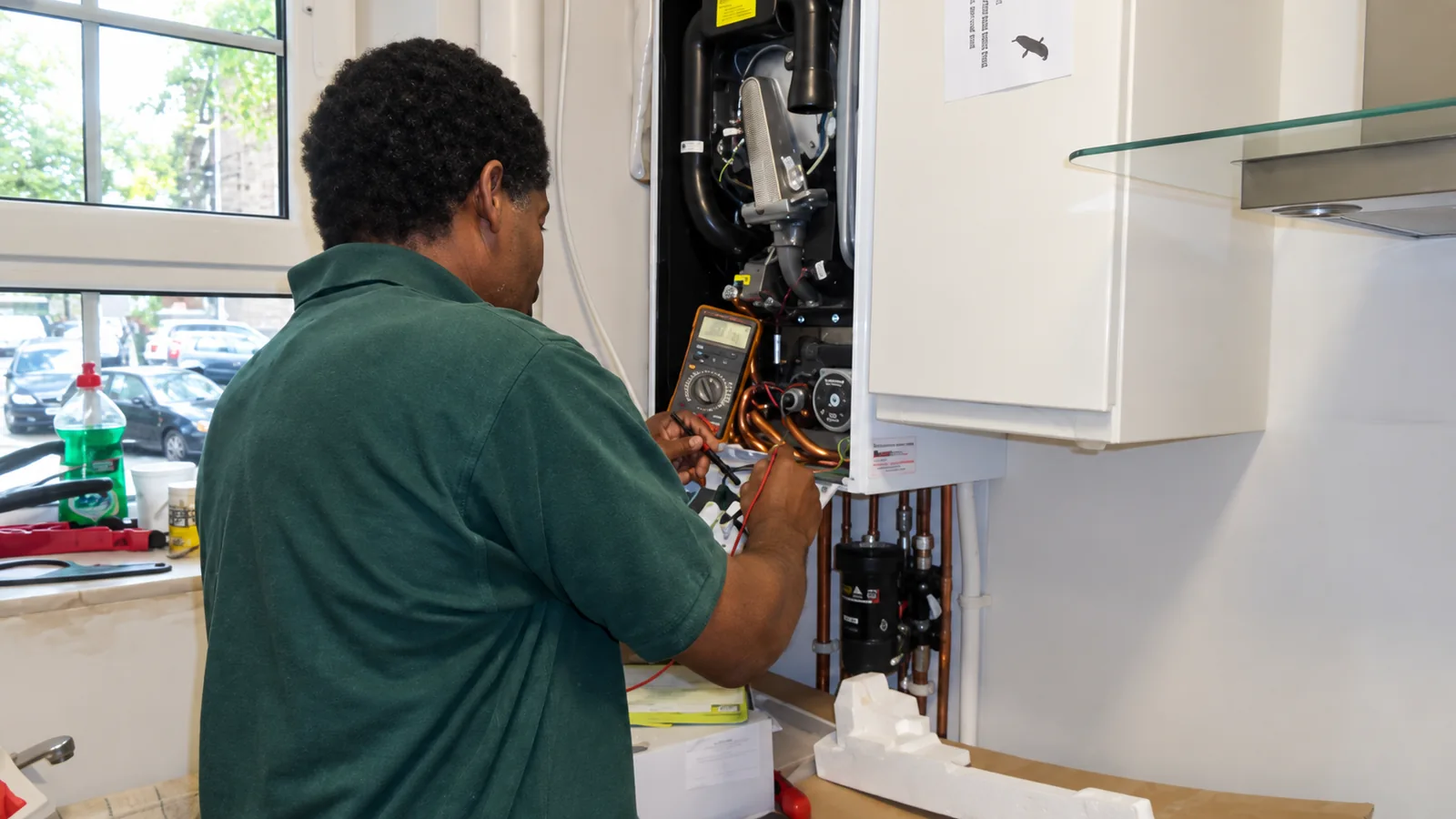 Carlton Fuller checking a wall-mounted boiler